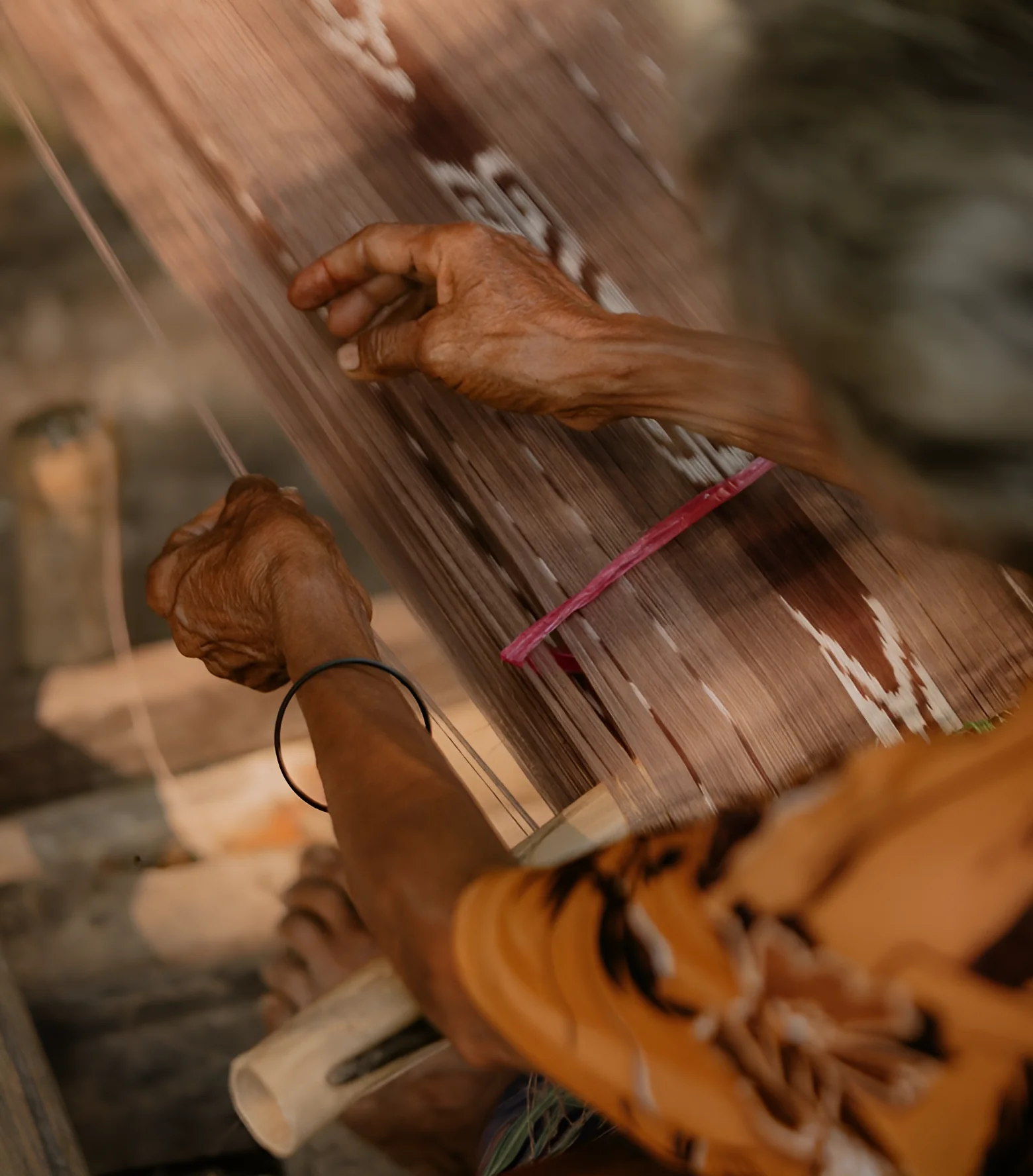 Master Artisan at Loom (Hand-sorting pattern threads during delicate manual weaving process)