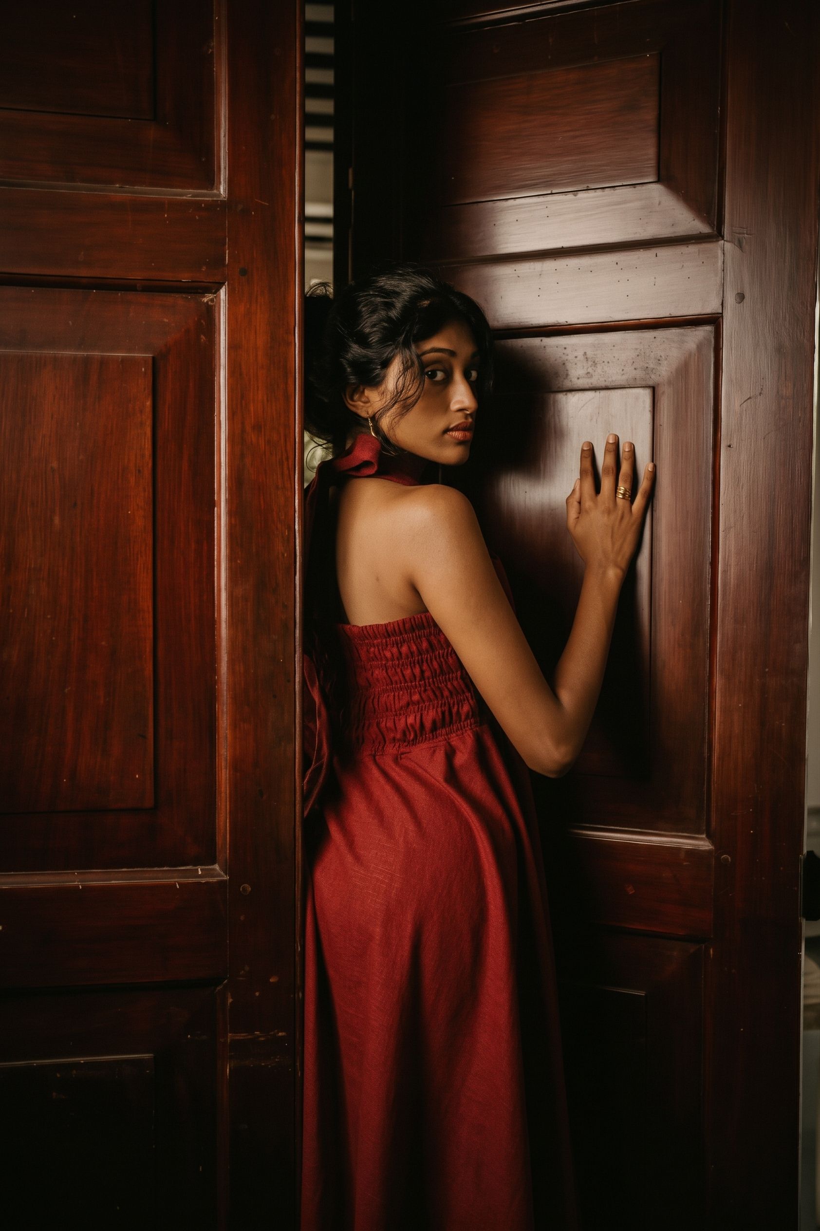 Cintamani linen halter dress beside carved teak doors at the Walawwa